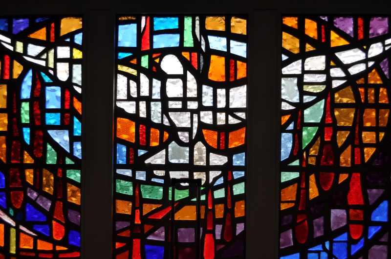3 panel stained glass window of a dove with outstretched wings representative of the Coming of the Holy Spirit in Acts