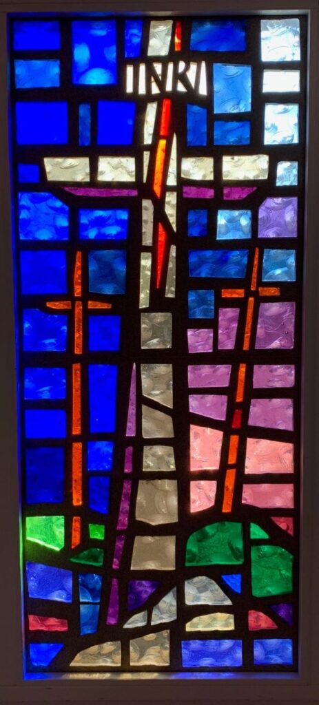 Stained glass window of 3 crosses representative of the Matthew, Luke and John stories of the Crucifixion of Jesus