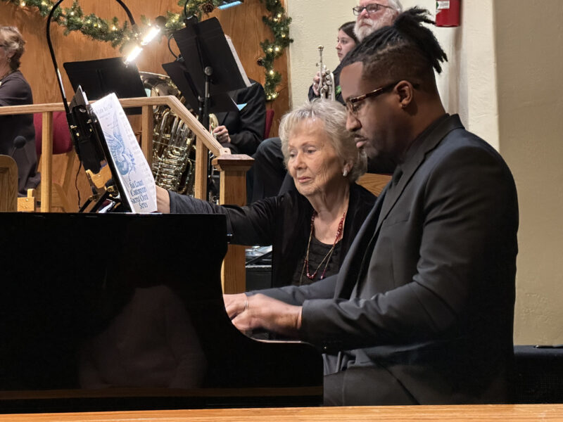 Church Organist Justin McCoy sits and plays while Carol Morris turns pages